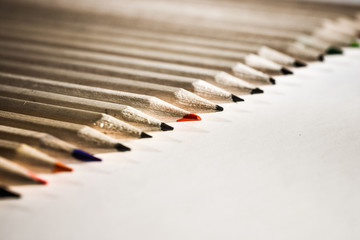 A shallow depth of field closeup photo of a  black and red pencils on a light background