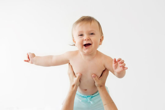 portrait of a smiling baby being hold in the air