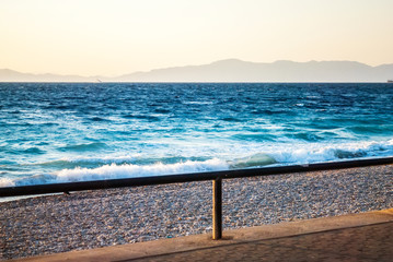 Sunset over the sea, with a strong shadow, blue sea and beaches
