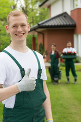 Smiling gardener standing with the thumb up