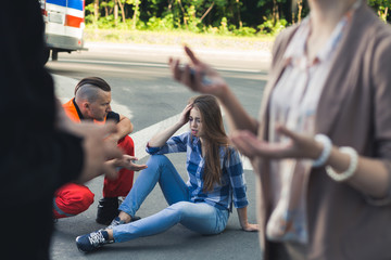 Car crash victim with paramedic helping her