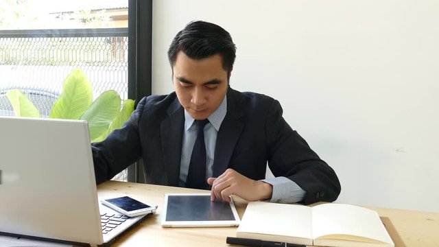 businessman working with laptop computer and tablet and touching digital display in office