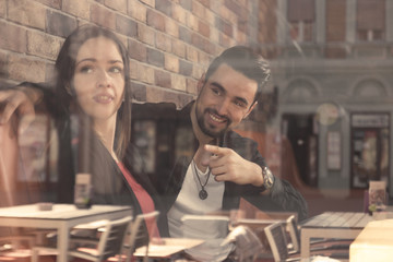 young woman man sitting caffee shop window reflection