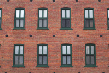 Fototapeta na wymiar red brick wall windows residential building facade