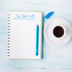 To do list white page flat lay and cup of espresso coffee green pastel background with blue pen