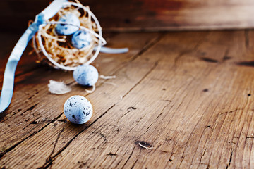 Easter basket with colored easter eggs  on old rustic wooden table.free text space. Selective focus.