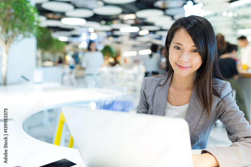 Poster businesswoman working on laptop computer in co working place