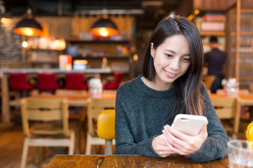 Woman working on cellphone in coffee  shop