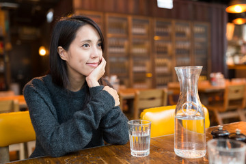 Woman thinking of something at coffee shop