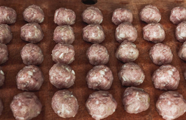 Home food, raw meatballs on a wooden board rural food