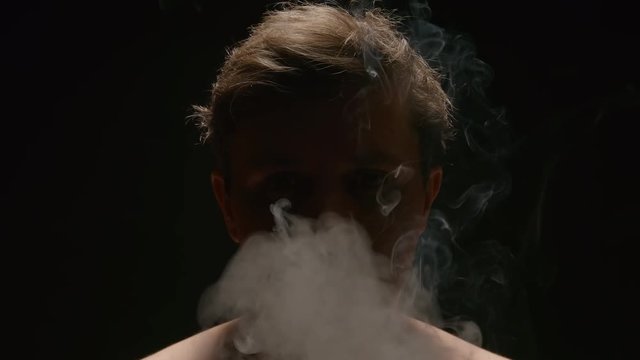 SLOW MOTION: Smoker exhales out a smoke