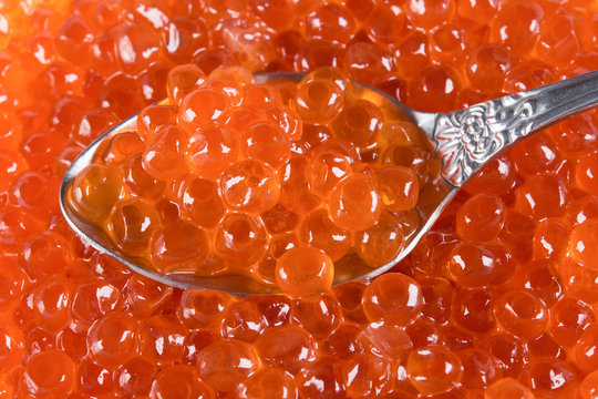 background with red caviar with a spoon in it