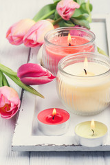 Obraz na płótnie Canvas Yellow and pink aroma candles with tulips