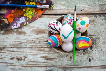 A Bowl full of colorful Easter eggs on a rustic table