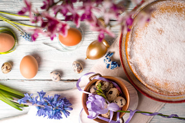 Easter decoration  , flowers and German Easter cake on the white wooden table top view
