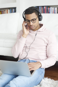 Enjoy the music. Afro American young man listening music on his laptop