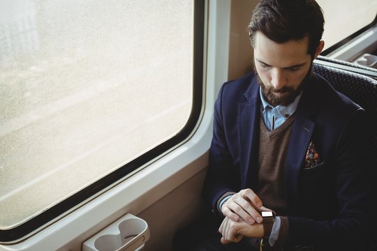 Businessman checking time on watch while travelling
