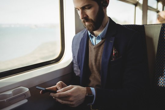 Businessman using mobile phone while travelling