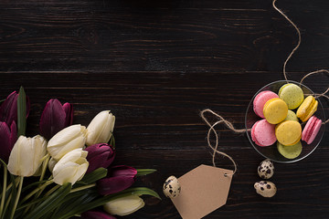 Easter eggs and tulips on dark wooden planks