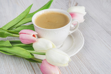 Fototapeta na wymiar beautiful white cup of beautiful coffee and white and pink tulips