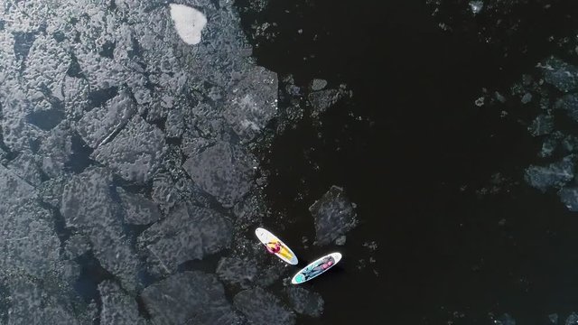 Aerial view of two athletes on the SUP. Winter. Ice.