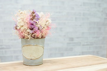 flower in retro vintage vase on wooden table with wall background, retro vintage concept with copy space for text.