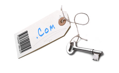 A silver key with a tag attached with a dot com concept written on it.