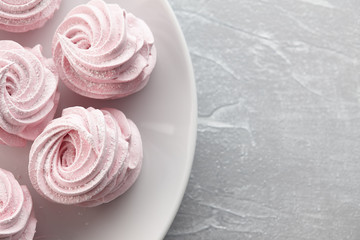 Pink homemade zephyr or marshmallow in white plate on light gray stone background