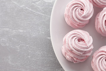 Pink homemade zephyr or marshmallow in white plate on light gray stone background