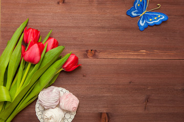 RED TULIPS FLOWERS ON WOODEN TABLE
