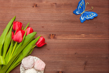 RED TULIPS FLOWERS ON WOODEN TABLE