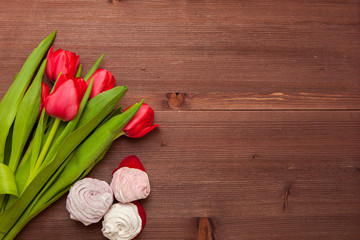 RED TULIPS FLOWERS ON WOODEN TABLE