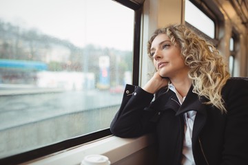Woman looking out through train window