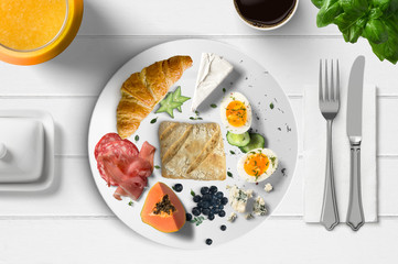 Frühstück - gedeckter Tisch mit Saft, Brötchen, Obst, Eier, Käse, Kaffee