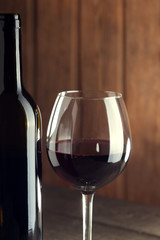 bottle of wine and a glass on old wooden table