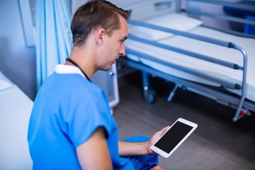 Naklejka na ściany i meble Doctor using digital tablet in ward