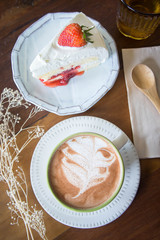 coffee cup and delicious cake strawberry and relax time moblie on table in coffee shop