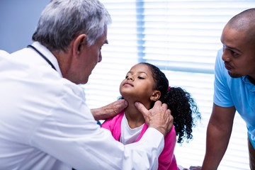 Fototapeta premium Doctor examining patients neck
