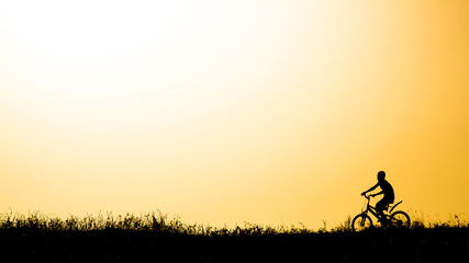 Fototapeta na wymiar Bicycle boy Orange background,Silhouette.
