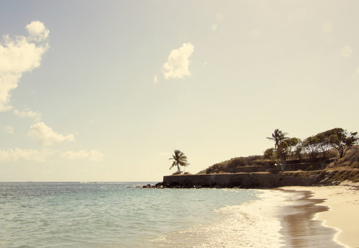 Edge Of White Sand Cockleshell Beach With Rock Retaining Wall In St. Kitts 