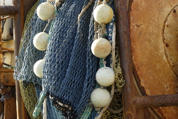 Closeup of trawl net wrapped around winch drum on the stern of a fishing boat
