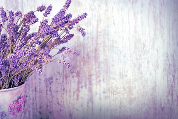 Bouquet of dry lavender in vase with rustic wooden background