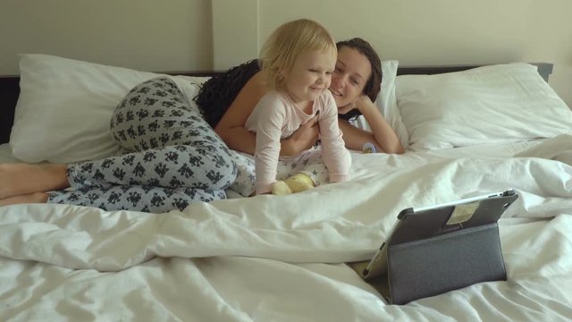 Mother and daughter watching cartoons on tablet computer