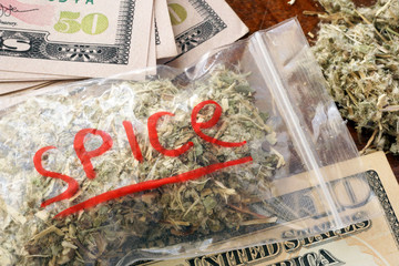Bag of weed with sign Spice on a dollar banknotes.