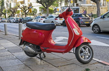 Small red motorbike parked on Tel-Aviv street