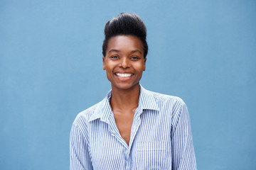 Fototapeta premium beautiful young black woman smiling against blue background