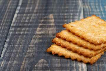 Crackers with sesame seeds and sugar lie on a wooden background. Selective focus. Place for text on the left.