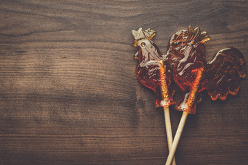 sugar lollipops rooster shaped on wooden table
