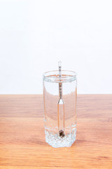 Full glass of vodka with alcoholmeters in close-up. Rules of measurement of alcoholic beverages fortress. Alcohol addiction.