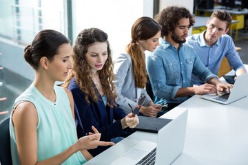 Business team discussing over laptop in meeting
